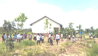 学校農園予定地を除草する先生と児童
